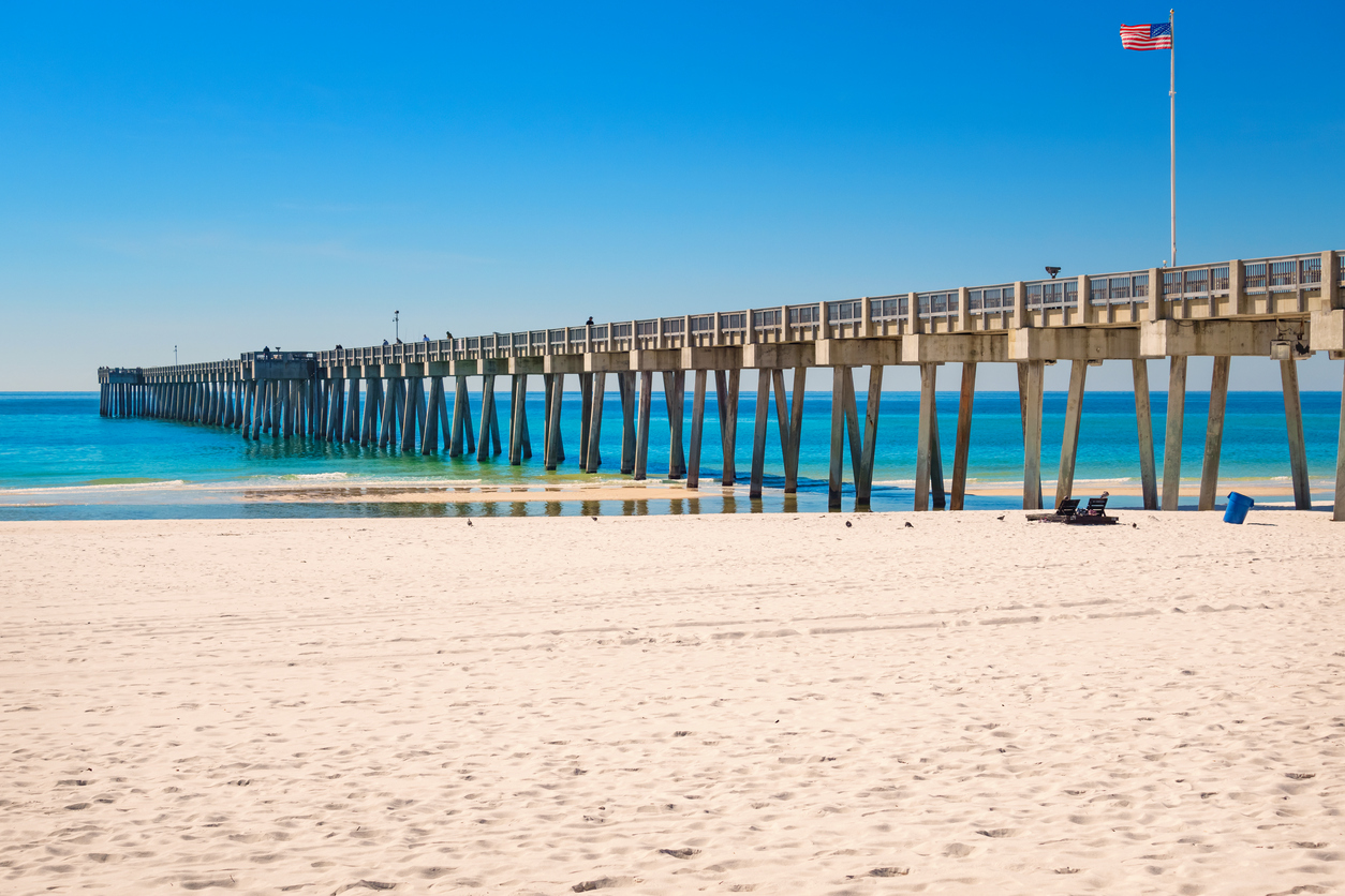 Photo of the City Pier and white sand beach at Panama City Beach, Florida, USA on a clear blue sky day.