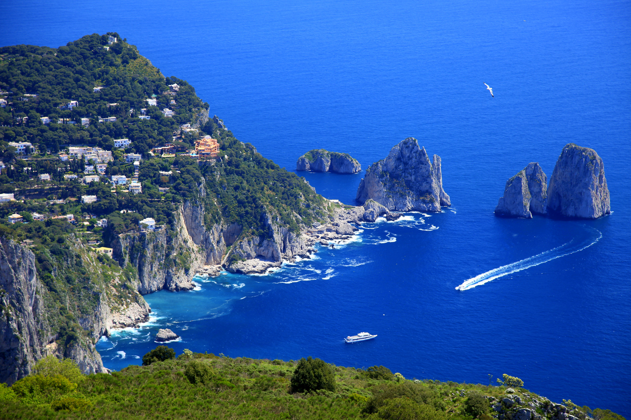 Above Capri Island boats and Faraglioni - Blue mediterranean, Italy